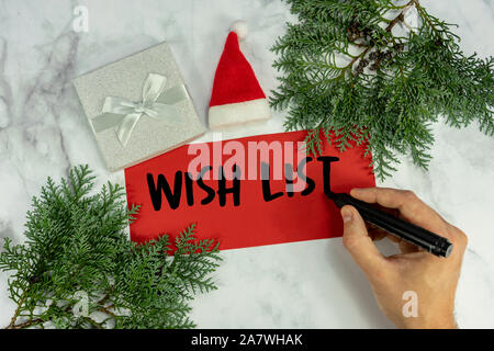 wish list on marble christmas background with man writing his wish list pine frame , Stock Photo
