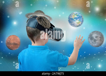 Boy with virtual reality glasses rotate planets concept. Fun and learning with apps and virtual reality devices. Stock Photo