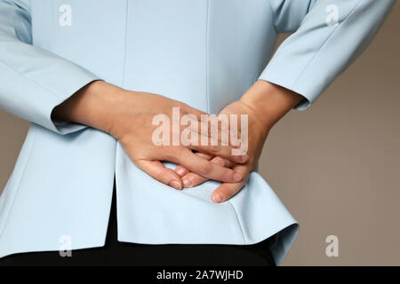 Back pain, woman in office suit suffering from backache. Female hands holding lower back, kidney or spine disease Stock Photo