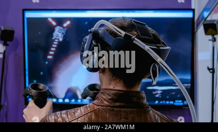 Man using virtual reality headset and playing action shooter game Stock Photo