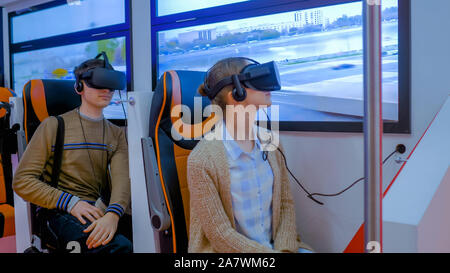 Young woman and man using virtual reality glasses and looking around: VR concept Stock Photo
