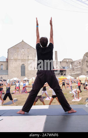 Male yoga instructor on stage demonstrating asana during yoga festival in the ground of Haapsalu Castle, Haapsalu, Estonia Stock Photo