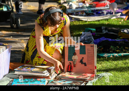 Young woman browsing through vinyl records collection at Karhupuisto pop-up flea market in Kallio district of helsinki, Finland Stock Photo