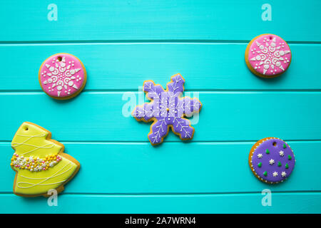 Assorment of traditional gingerbread cookies for Christmas on turquoise background, top view. Christmas tree, snowflakes and balls. Stock Photo
