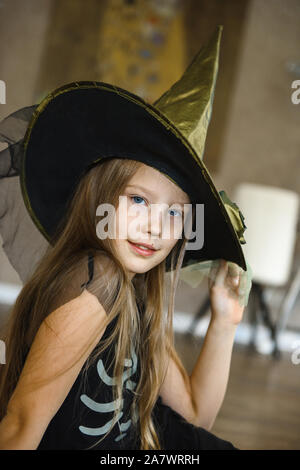 Smiling Teenage Girl in Hat Dressed for Halloween in Witch Costume Stock Photo