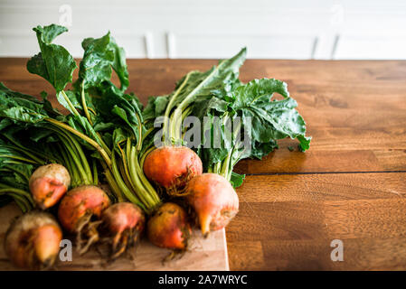 close up shot of freshly picked beets with greens laying on a table Stock Photo