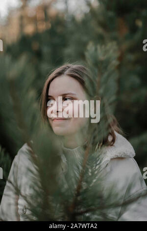 woman standing amidst pine trees at forest Stock Photo