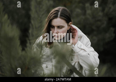 woman standing amidst pine trees at forest Stock Photo