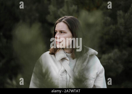 woman standing amidst pine trees at forest Stock Photo