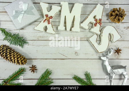 Christmas frame background flat lay on white wood with gift box xmas text and other natural decoration . Stock Photo
