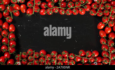 Group of red cherry tomatoes on black marble like board, view from above. They form frame with space for text in middle Stock Photo