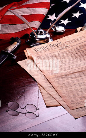Still life of the Constitution of the United States of America with American flag, quill pen, inkwell, and antique specs Stock Photo