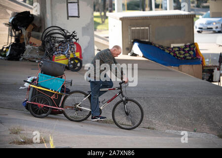Homeless Texan leaves temporary encampment under highway overpass as state highway workers move in,  ordered by Texas Gov. Greg Abbott to clean up homeless areas in the public right-of-way. There are 17 identified sites scheduled for cleanup in the Austin area. Stock Photo