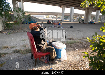 Days before a threatened crackdown by Texas Governor Greg Abbott on public right-of-way camping, a homeless Texan awaits  the governor's and highway department actions in Austin. Most are unsure where they will go as local shelters are over capacity. Stock Photo