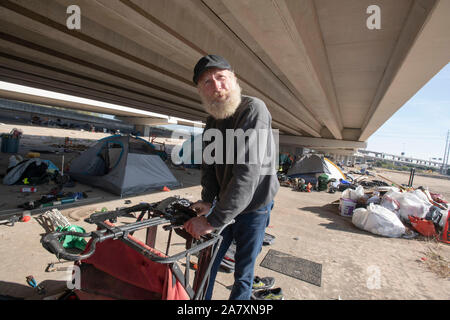 Homeless Texan leaves temporary encampment under highway overpass as state highway workers move in, ordered by Texas Gov. Greg Abbott to clean up homeless areas in the public right-of-way in Austin, TX. There are 17 identified sites scheduled for cleanup in the Austin area. Stock Photo