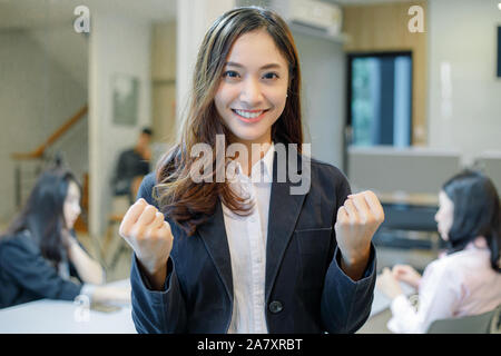 Asian  businesswomen Success and winning concept - happy team with raised up hands celebrating the breakthrough and achievements Stock Photo