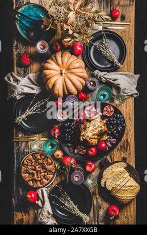 Thanksgiving party table setting with roasted chicken and seasonal produce Stock Photo