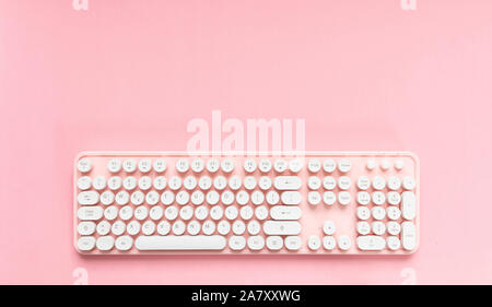 Computer keyboard pink with white buttons isolated against pink background, copy space Stock Photo