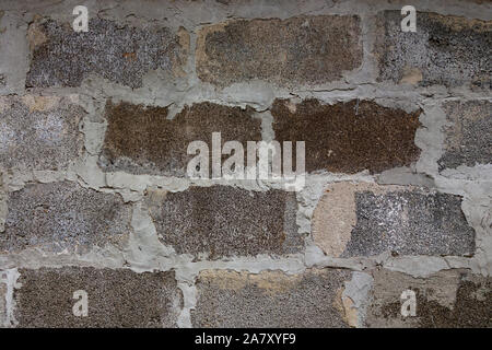 Gray block wall background. Grey textured building exterior surface with rough stacked big bricks. Tiled structure of stonewall for backdrop designs Stock Photo
