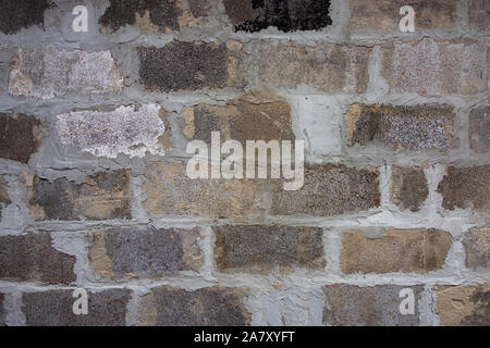 Gray block wall background. Grey textured building exterior surface with rough stacked big bricks. Tiled structure of stonewall for backdrop designs Stock Photo