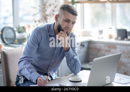 Businessman feeling concerned while preparing financial report Stock Photo