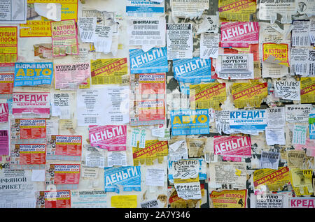 KHARKOV, UKRAINE - OCTOBER 2, 2019: Grunge Message Board with many advertisement. People spreading advertising and information on white paper than pos Stock Photo