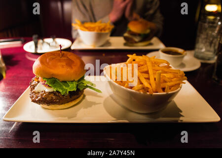 Tasty Hamburger & fries at Baton Rouge in Montreal (Quebec, Canada). Canadian restaurant chain, famous for their baby back ribs, Sterling Silver steak Stock Photo