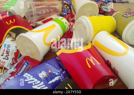 KHARKOV, UKRAINE - NOVEMBER 1, 2019: Many used food wrappings and drink cans by random food manufacturing famous brands. Recycled trash of treats and Stock Photo