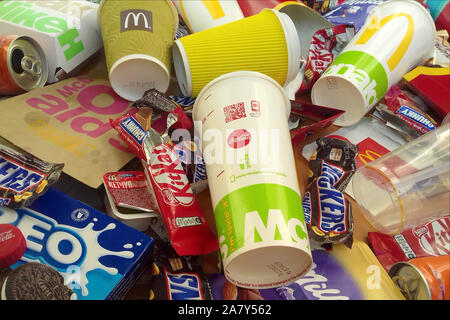 KHARKOV, UKRAINE - NOVEMBER 1, 2019: Many used food wrappings and drink cans by random food manufacturing famous brands. Recycled trash of treats and Stock Photo