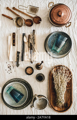 Various kitchen utensils and tablewear over linen tablecloth, vertical composition Stock Photo