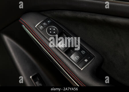 The control buttons for opening and closing windows of doors and electric controls and settings of mirrors on the door in black with leather upholster Stock Photo