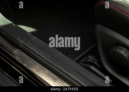Clean after washing front drivers carpet floor in black color inside the interior of an expensive luxury sedan preparation before selling the car in t Stock Photo