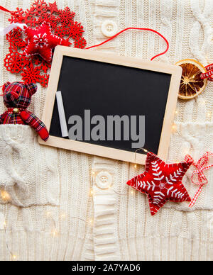 Flat lay view of empty black chalkboard for making Christmas gifts wish list, card or write a letter to Santa Clause, Christmas commercial background. Stock Photo