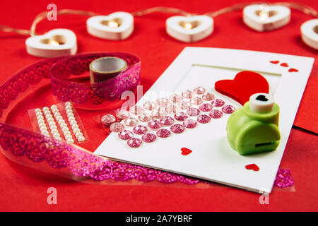 Making Greetings card concept. Various arts and crafts tools on table, red background. Stock Photo