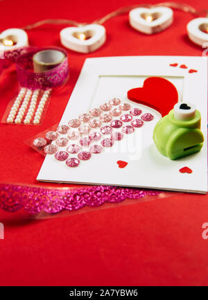 Making Greetings card concept. Various arts and crafts tools on table, red background. Stock Photo