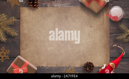 Blank old vintage paper surrounded by Christmas decorations and gifts. Greeting card concept. Mockup, top view, flat lay composition. Stock Photo