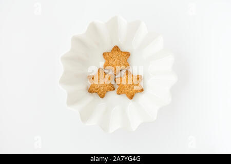Top view of homemade Christmas shortbread cookies in white bowl isolated on white background. Stock Photo