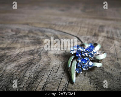 Brooch in blue gemstone for clothes isolated on wooden background. Stock Photo