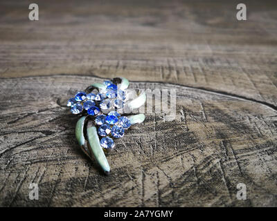 Brooch in blue gemstone for clothes isolated on wooden background. Stock Photo