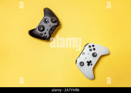 White and black two joystick gamepad, game console on yellow colourful trendy modern fashion pin-up background. Computer gaming competition videogame control confrontation concept. Cyberspace symbol Stock Photo
