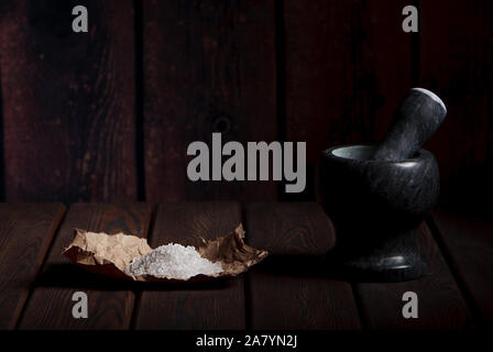 Mortar and solt on an old wooden table Stock Photo