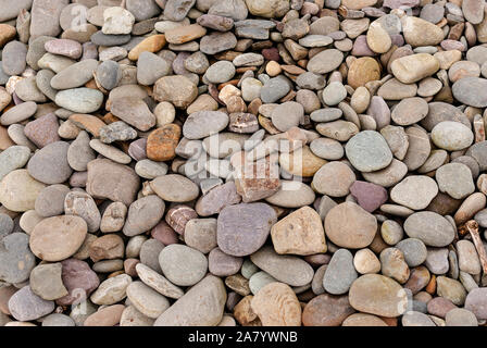 Smooth stones texture background. Rounded stones on Atlantic ocean coast. Stock Photo