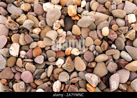 Smooth stones texture background. Rounded stones on Atlantic ocean coast. Stock Photo