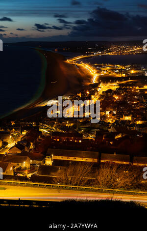 Portland Dorset England Night time view over the town of Fortuneswell, and Chesil Beach, seen from Portland Heights Stock Photo