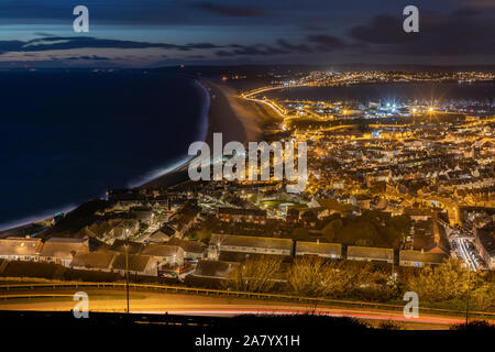 Portland Dorset England Night time view over the town of Fortuneswell, and Chesil Beach, seen from Portland Heights Stock Photo