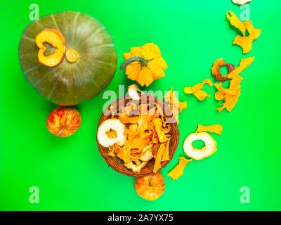 Dried fruits and vegetables slices apple, pumpkin in brown wicker basket on green background. Selective focus. Stock Photo