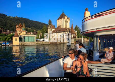 Ship passes by a castle on the shore of lake Thun, Switzerland Stock Photo