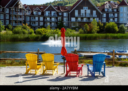 Colorful Muskoka chairs on Mill pond dock during fall at Blue Mountains Village Stock Photo