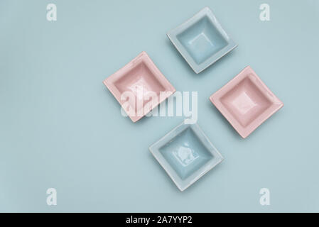 Four small decorative tabletop bowls pink and light blue on a light blue backround Stock Photo