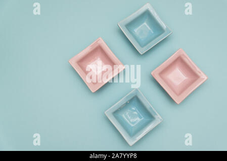 Four small decorative tabletop bowls pink and light blue on a light blue backround Stock Photo